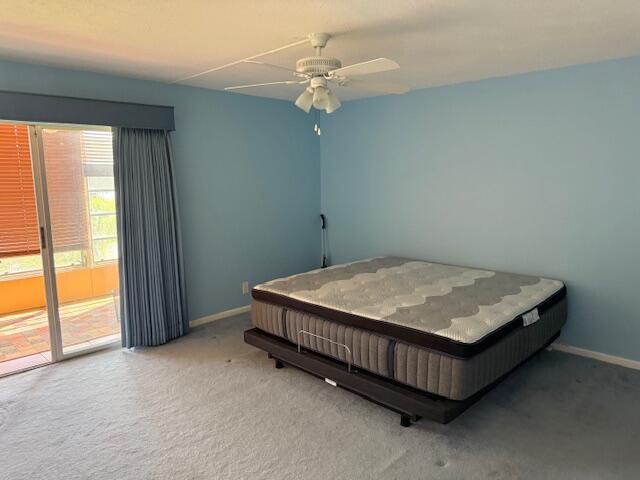 A bedroom with light blue walls, gray carpeting, a ceiling fan, and a large mattress — 3092 Westbury H # 3092, Deerfield Beach FL 33442, DEERFIELD BEACH, FL