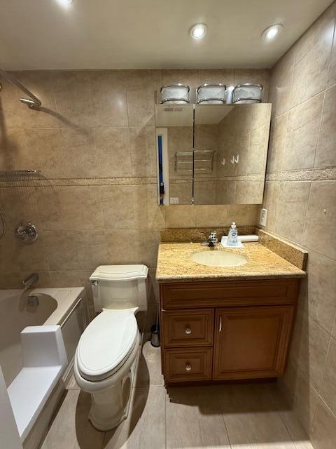 A bathroom features a beige tiled shower-tub combo, a toilet, and a wooden vanity cabinet — 3092 Westbury H # 3092, Deerfield Beach FL 33442, DEERFIELD BEACH, FL