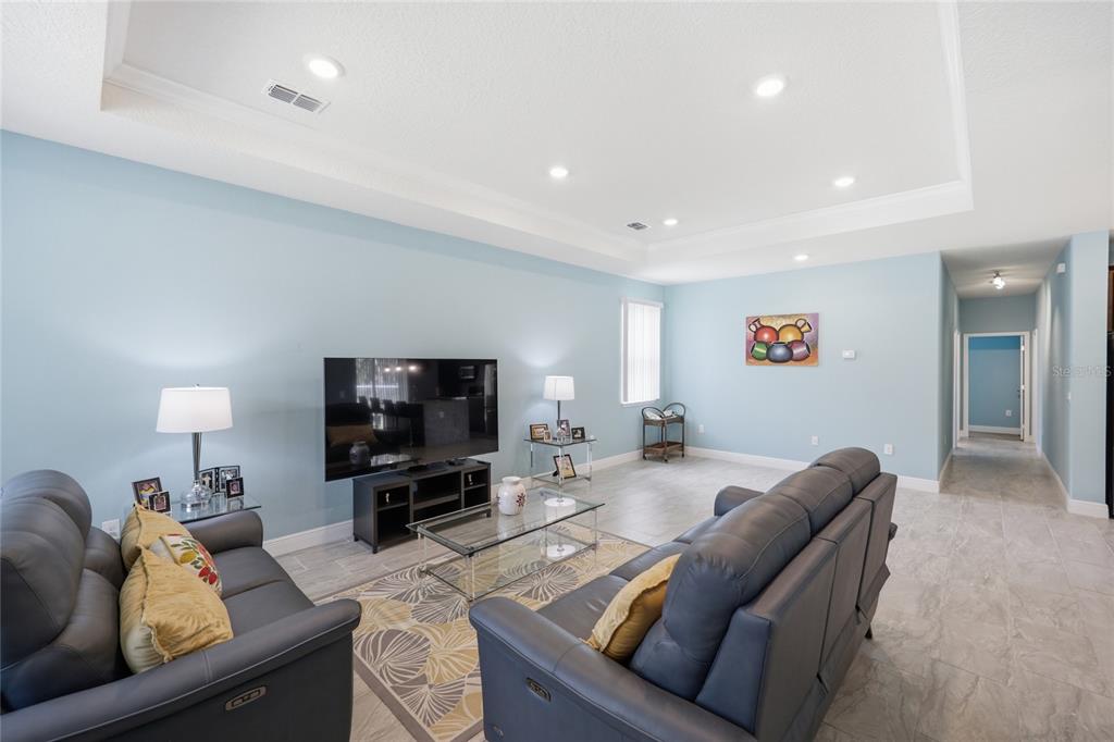 A living room features light blue walls, a tray ceiling, and a beige sectional sofa — 2118 W HAMPSHIRE BOULEVARD, CITRUS SPRINGS, FL