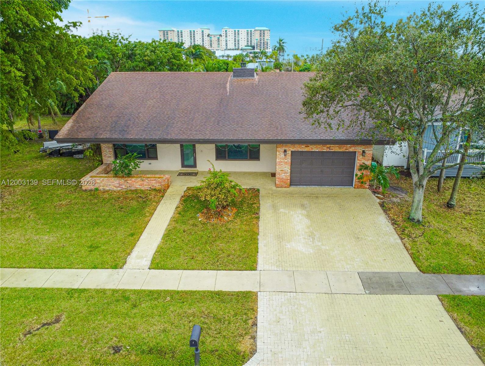 An aerial view shows a single-story brick house with a brown roof and paved driveway — 614 NE 3rd St, Dania Beach FL 33004, DANIA BEACH, FL