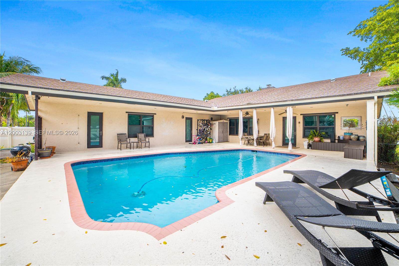 A backyard features a swimming pool, a concrete patio, and a sprawling L-shaped house — 614 NE 3rd St, Dania Beach FL 33004, DANIA BEACH, FL