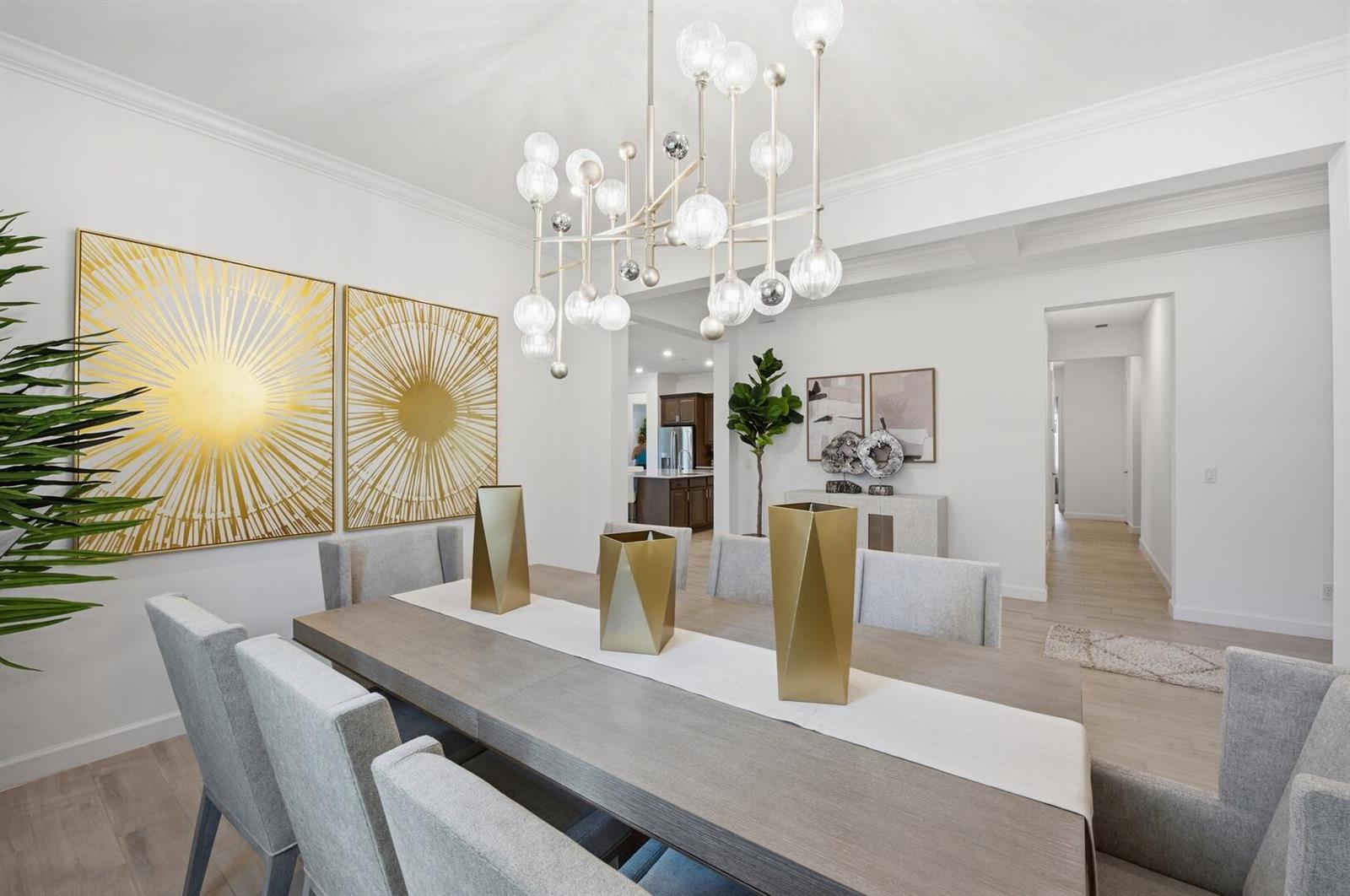 A dining room features a long wooden table, gray upholstered chairs, and a modern chandelier — 732 Hookline Circle, Loxahatchee FL 33470, LOXAHATCHEE, FL