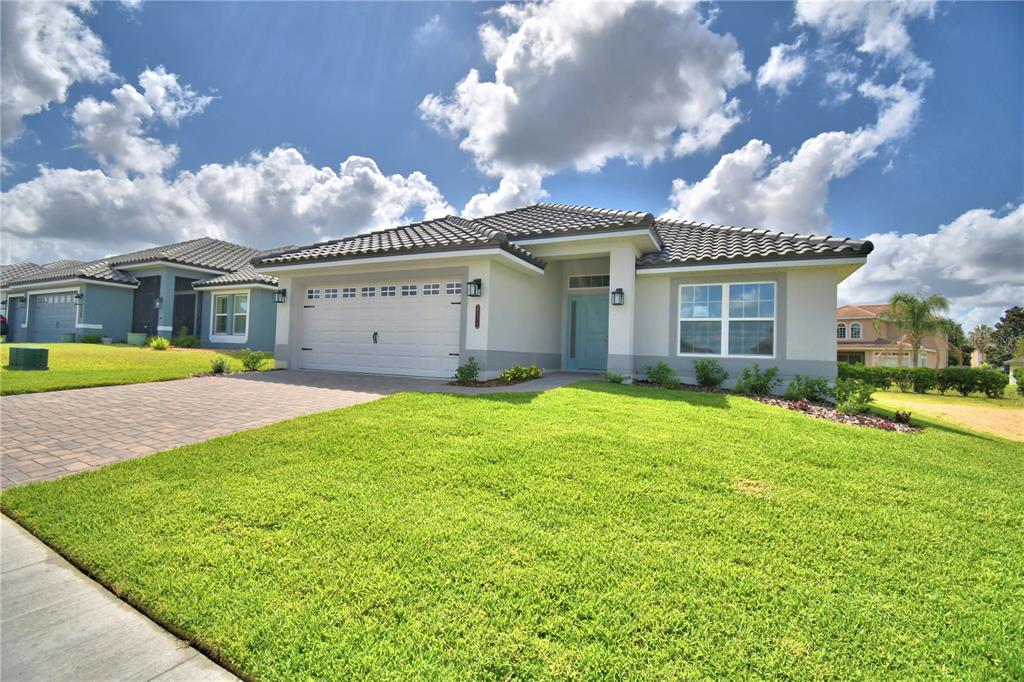 A single-story house with a white garage, light blue front door, and tiled roof — 4514 GRANDVIEW GLEN DRIVE, AUBURNDALE, FL