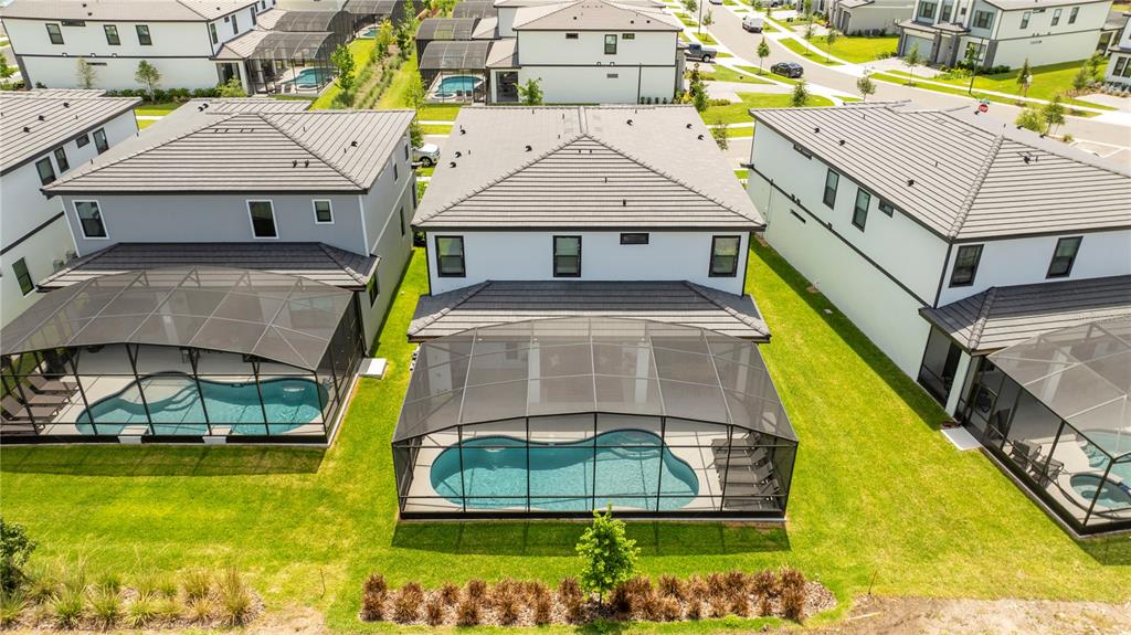 An aerial view shows three suburban houses with screened-in pools and backyards — 10018 VOYAGER WAY, ORLANDO, FL