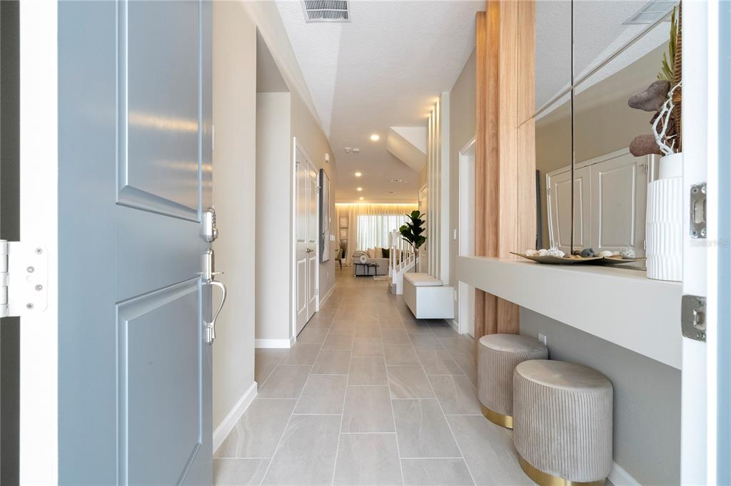 A view from an open doorway into a hallway with tile floors and a console — 10018 VOYAGER WAY, ORLANDO, FL
