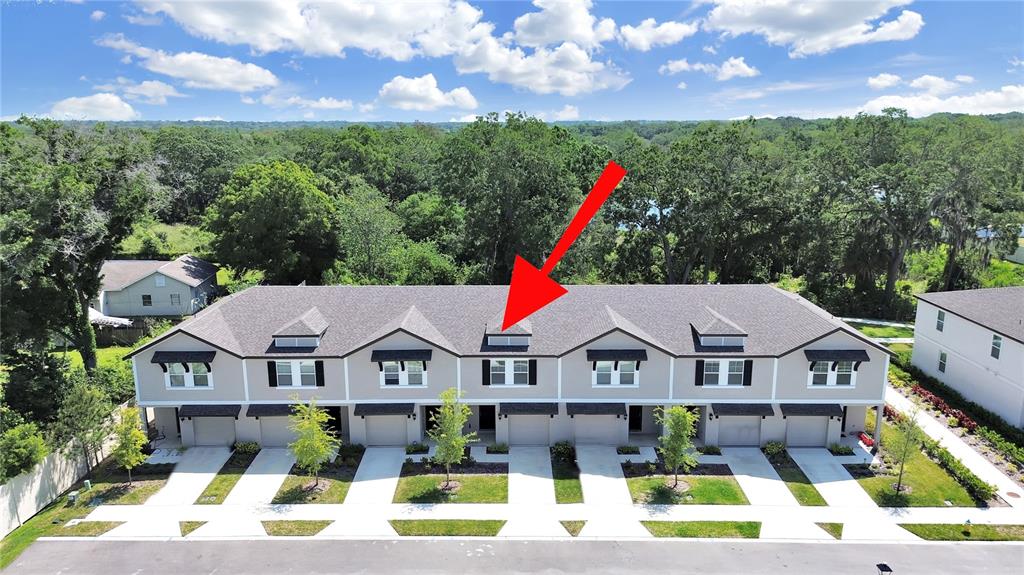 An aerial view shows a row of townhouses with a red arrow pointing to a dormer — 2763 SCARLET BAY PLACE, BRANDON, FL