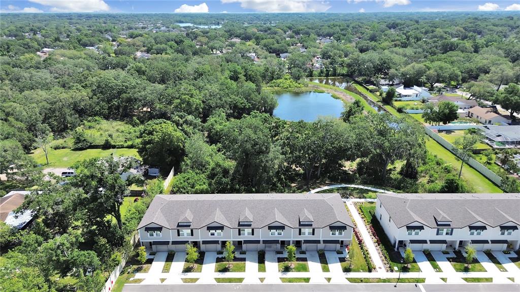 An aerial view shows two rows of modern townhouses with gray roofs near a pond — 2763 SCARLET BAY PLACE, BRANDON, FL