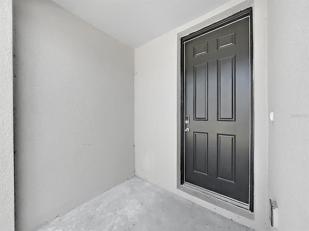 A dark gray front door is set into a plain, light-colored exterior entryway — 2763 SCARLET BAY PLACE, BRANDON, FL