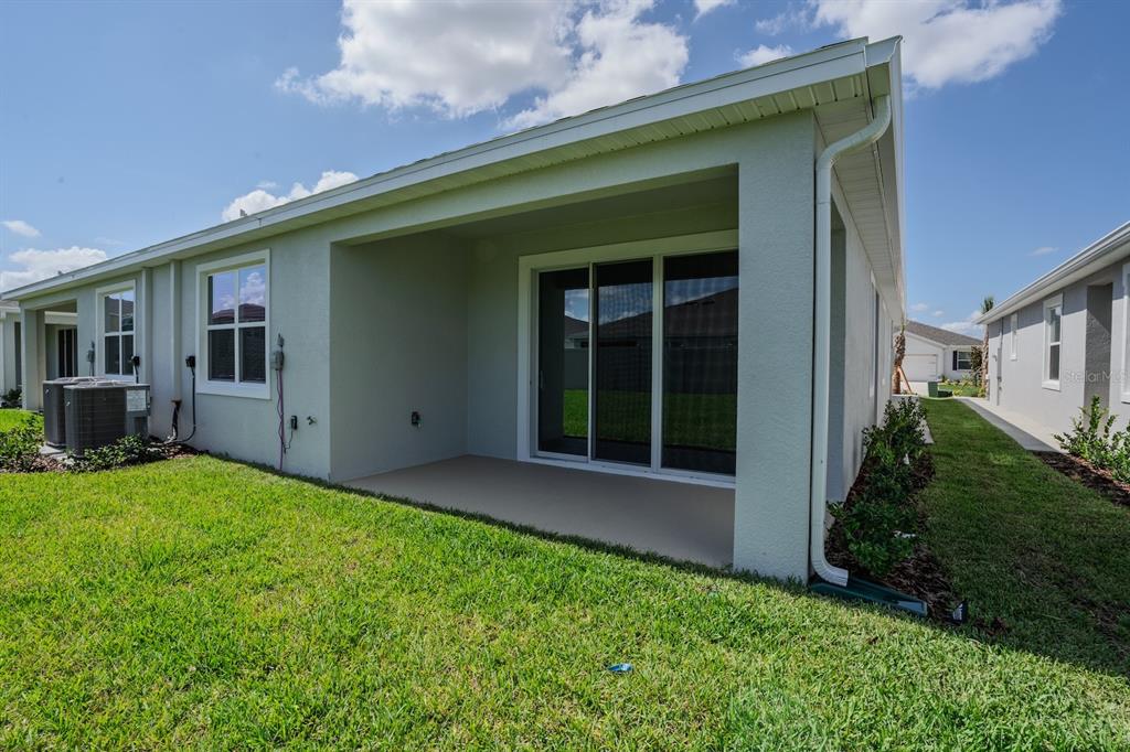 A view of a house exterior featuring a covered patio and sliding glass doors — 4008 WESTWOOD FIELDS LOOP, PLANT CITY, FL