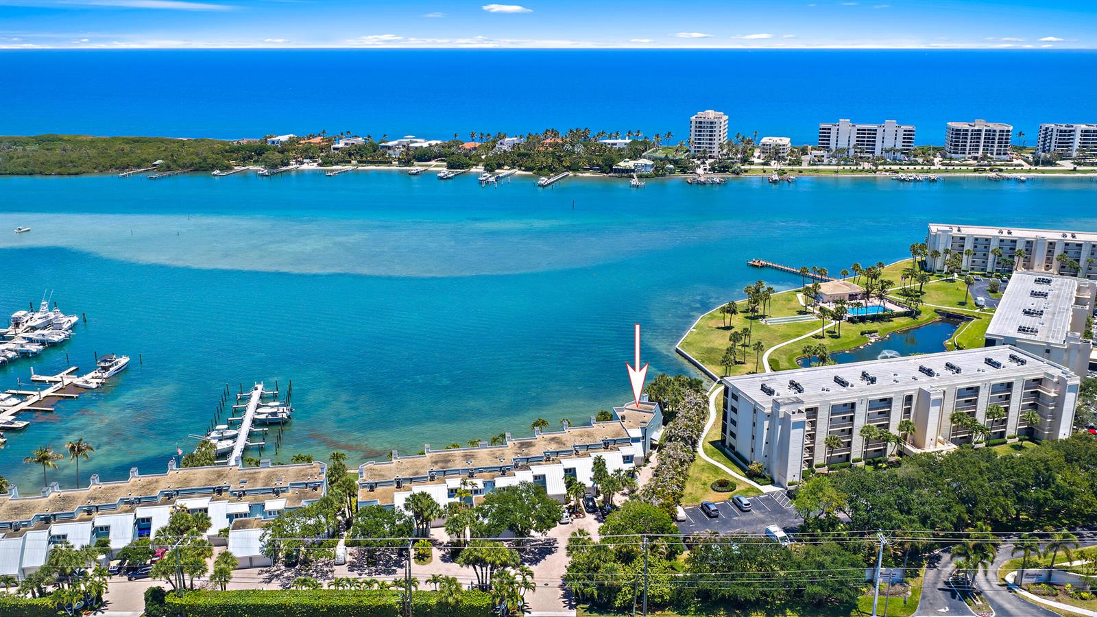 An aerial view shows a waterfront condominium complex with a marked unit and private docks — 19932 Scrimshaw Way, Jupiter FL 33469, JUPITER, FL