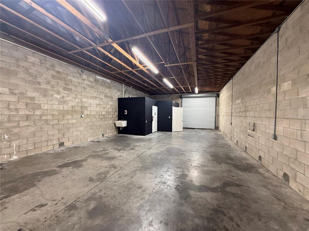 An empty industrial warehouse space features concrete block walls, a concrete floor, and exposed rafters — 4534 NE 35TH STREET UNIT 7, OCALA, FL
