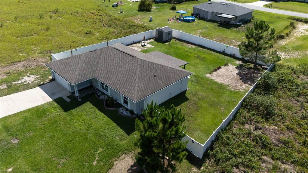 An aerial view of a single-story house with a fenced backyard and a storage shed — 263 EMERALD ROAD, OCALA, FL