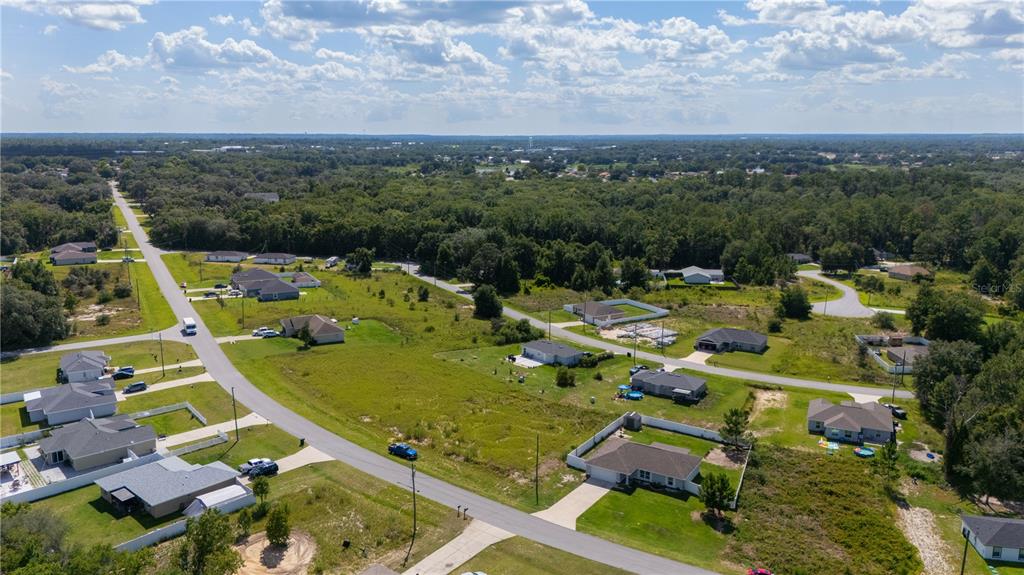 An aerial view shows several single-family homes scattered across a grassy, partially wooded residential area — 263 EMERALD ROAD, OCALA, FL