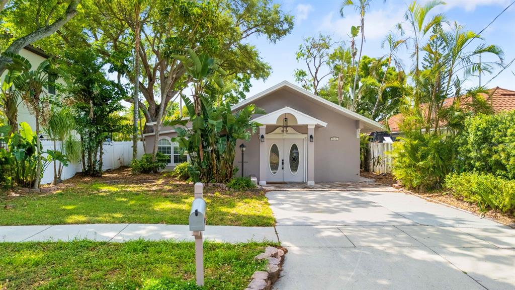 A single-story house with a gray exterior, double front doors, and a concrete driveway — 3414 W WALLCRAFT AVENUE, TAMPA, FL