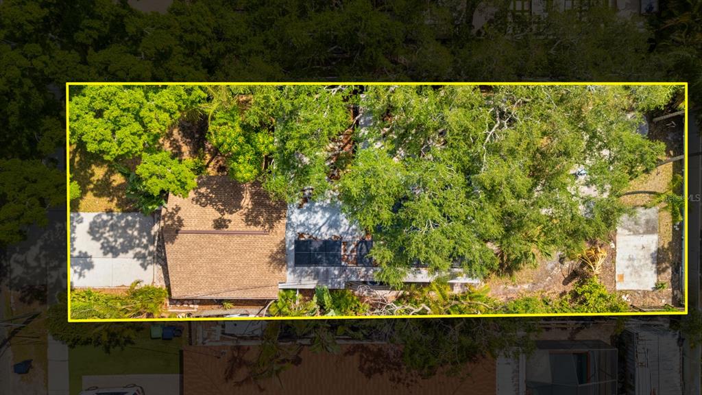 An aerial view shows a house with a shingled roof, solar panels, and surrounding trees — 3414 W WALLCRAFT AVENUE, TAMPA, FL