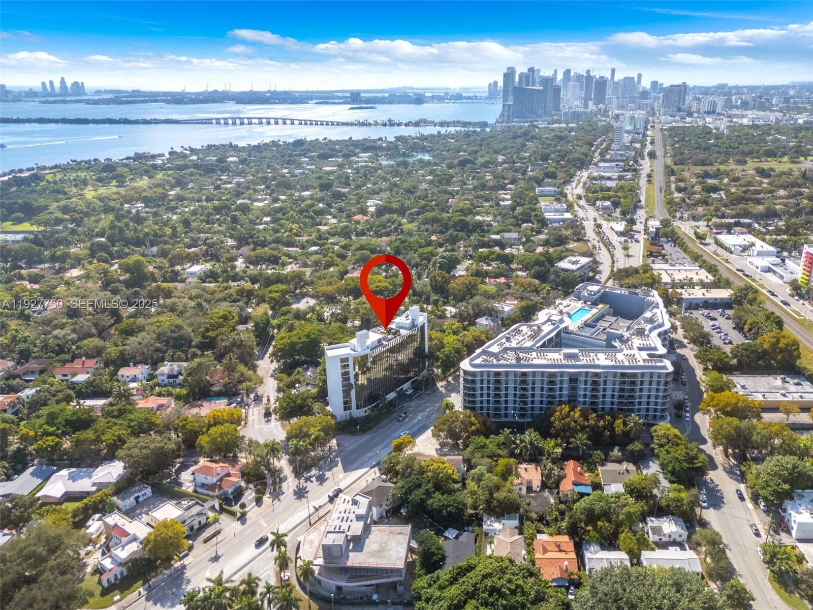 An aerial view shows a modern glass-facade building marked with a red location pin — 5701 Biscayne Blvd # 9, Miami FL 33137, MIAMI, FL