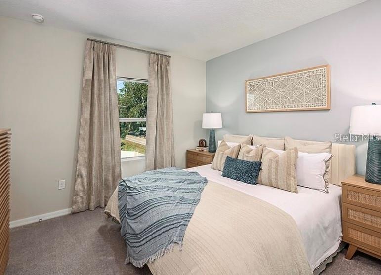 A bedroom features a bed with neutral bedding, two nightstands, and a window with curtains — 2852 SKYLINE LOOP, KISSIMMEE, FL
