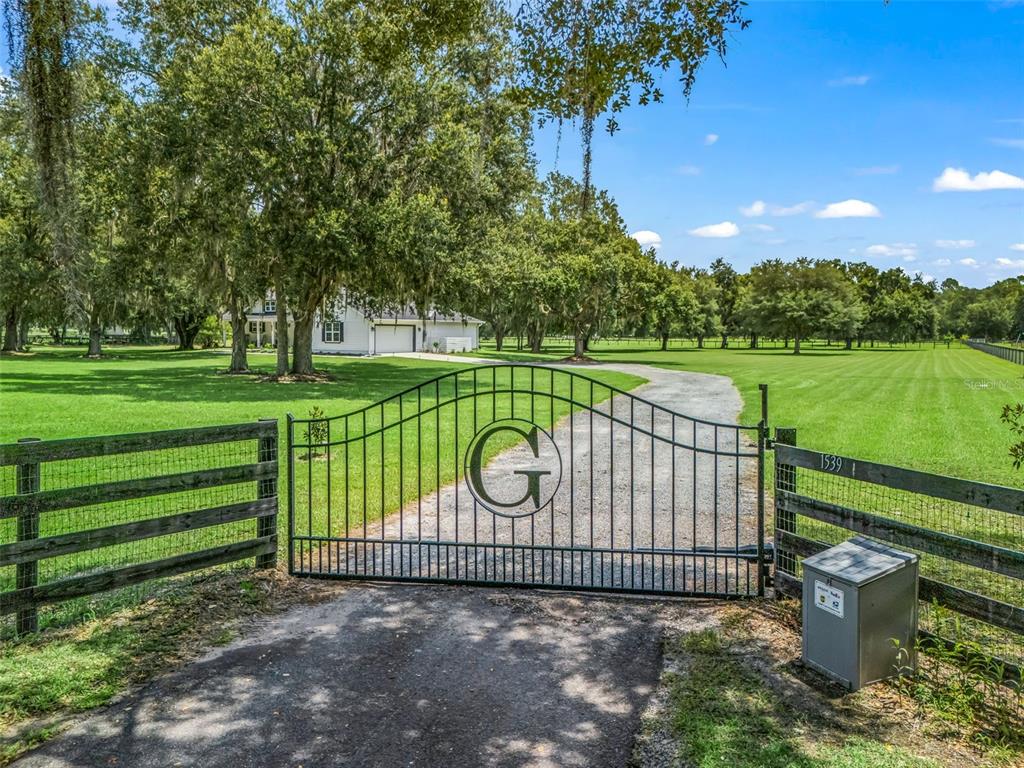 A white single-story house with a red front door sits on a grassy lawn — 1539 SE 34TH WAY, SUMTERVILLE, FL