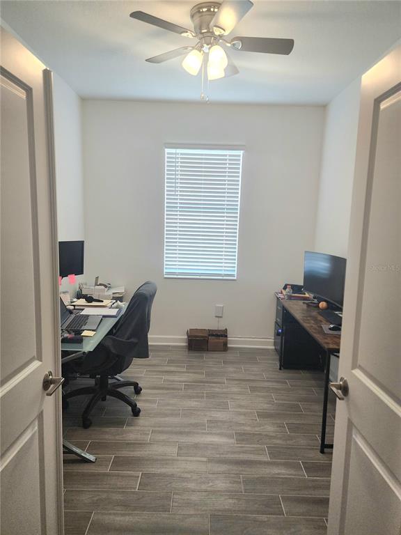 A home office with two desks, a ceiling fan, and gray wood-look tile flooring — 1743 GOOD NEIGHBOR LOOP, KISSIMMEE, FL