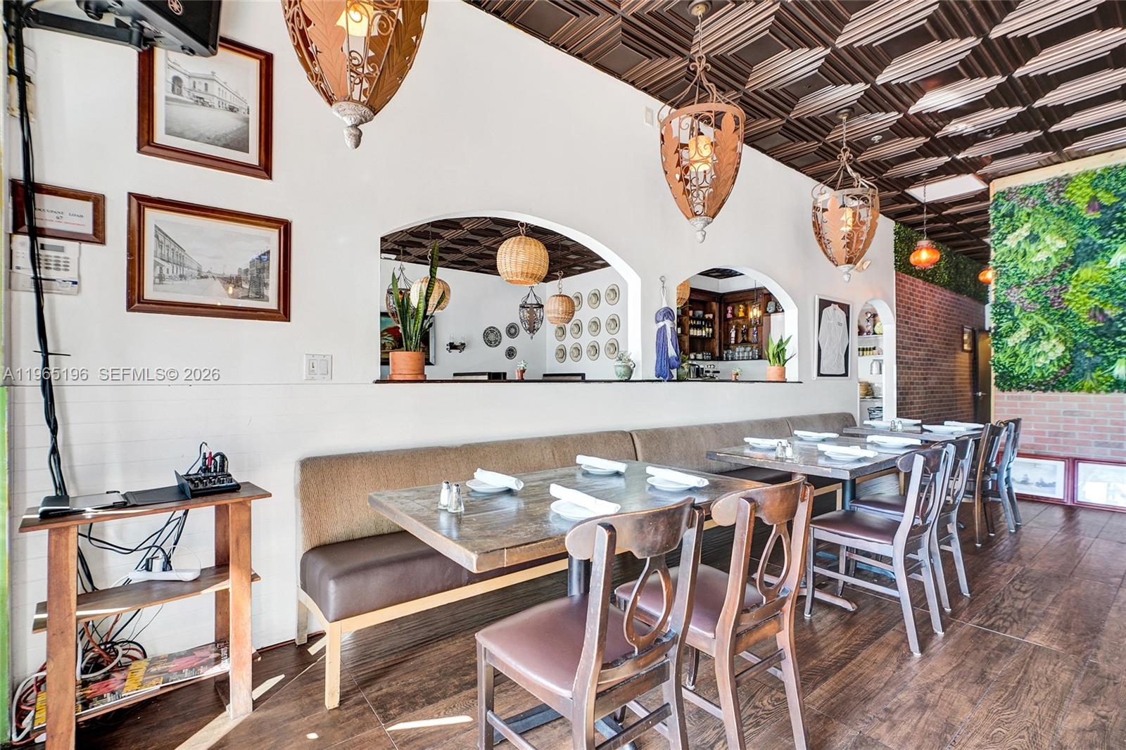A restaurant dining area features wooden tables, booth seating, decorative pendant lights, and a coffered ceiling — 15400 Biscayne Blvd, North Miami FL 33160, NORTH MIAMI, FL