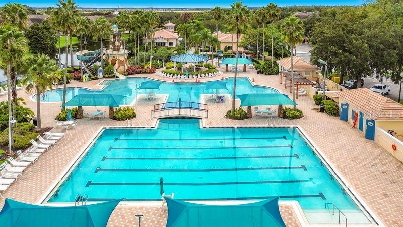 An aerial view of a large outdoor swimming pool complex with palm trees and cabanas — 8552 KESWICK POINTE DRIVE, ORLANDO, FL