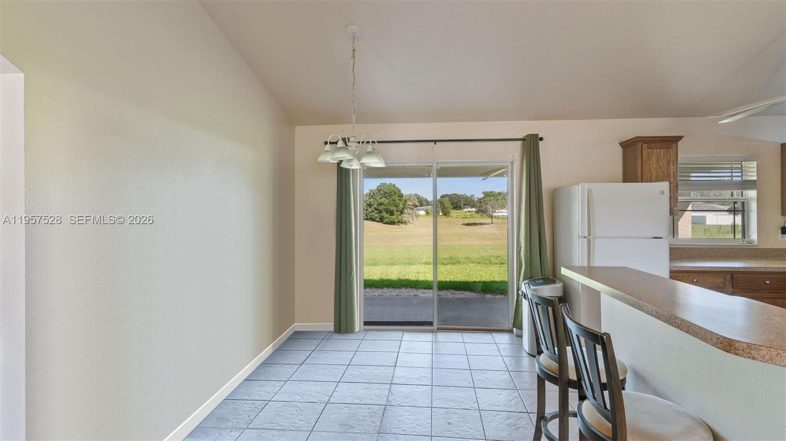 A dining area features tile flooring, a sliding glass door, and a breakfast bar — 87 Dogwood Drive Circle, Ocala FL 34472, OCALA, FL