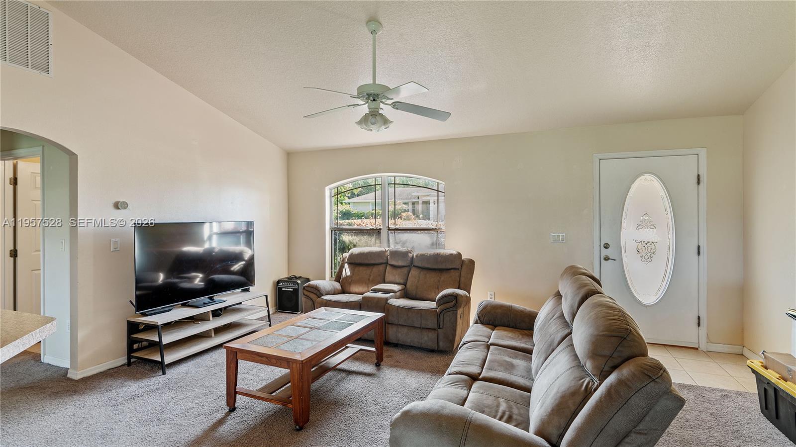 A living room features a television, two brown sofas, a coffee table, and a ceiling fan — 87 Dogwood Drive Circle, Ocala FL 34472, OCALA, FL
