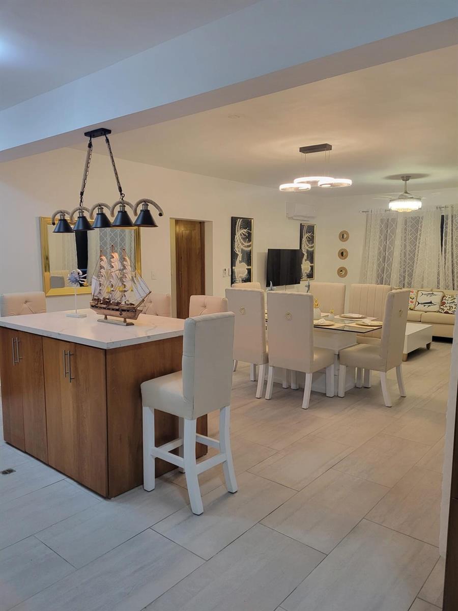 A kitchen island with a model ship sits before a dining area and living room — 0 Residencial Coralina # 3, FL