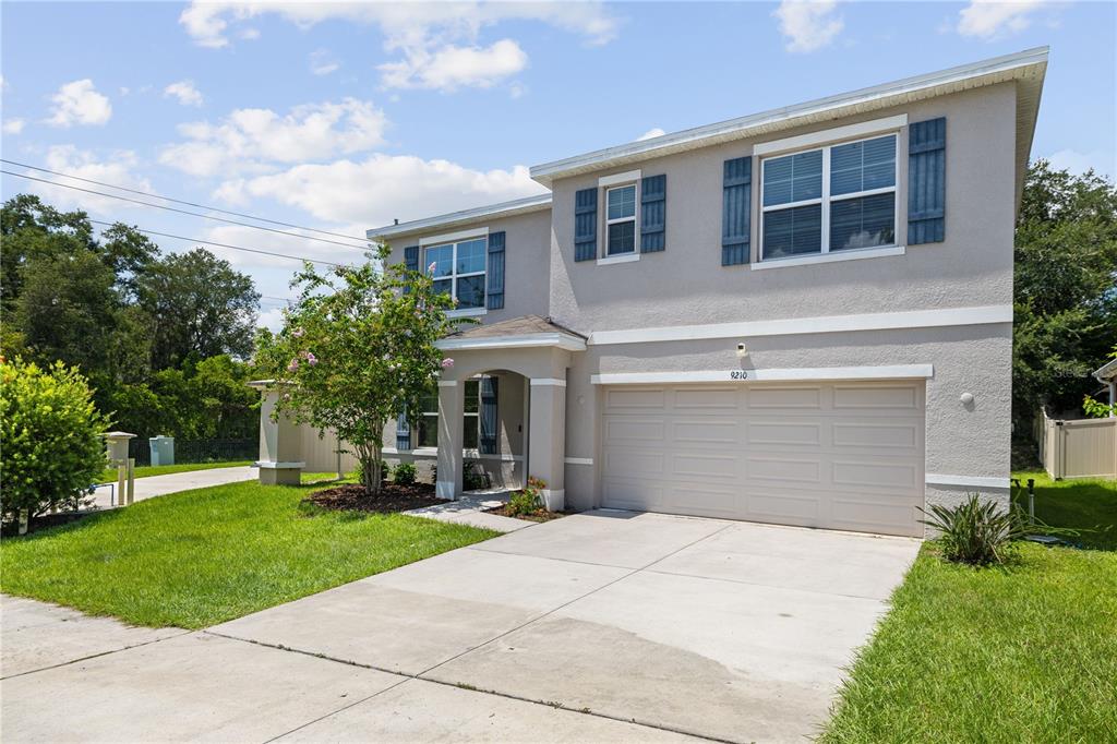 A kitchen features dark wood cabinets, granite countertops, a center island with stools, and tile flooring — 9210 WATOLLA DRIVE, THONOTOSASSA, FL