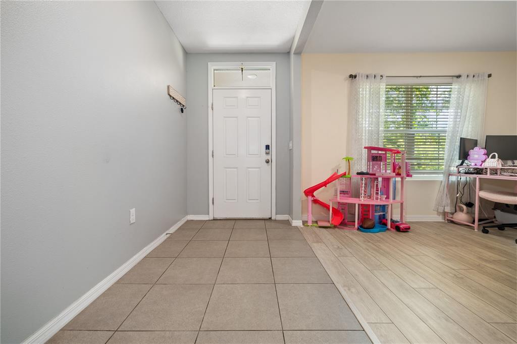 A kitchen with dark wood cabinets, granite countertops, a center island, and bar seating — 9210 WATOLLA DRIVE, THONOTOSASSA, FL