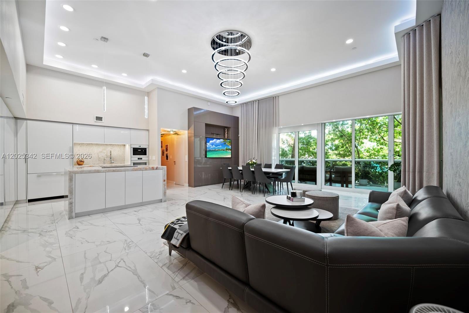 A modern open-concept living and dining area features marble floors, a large chandelier, and kitchen — 1800 S Ocean Dr # 310, Hallandale Beach FL 33009, HALLANDALE BEACH, FL