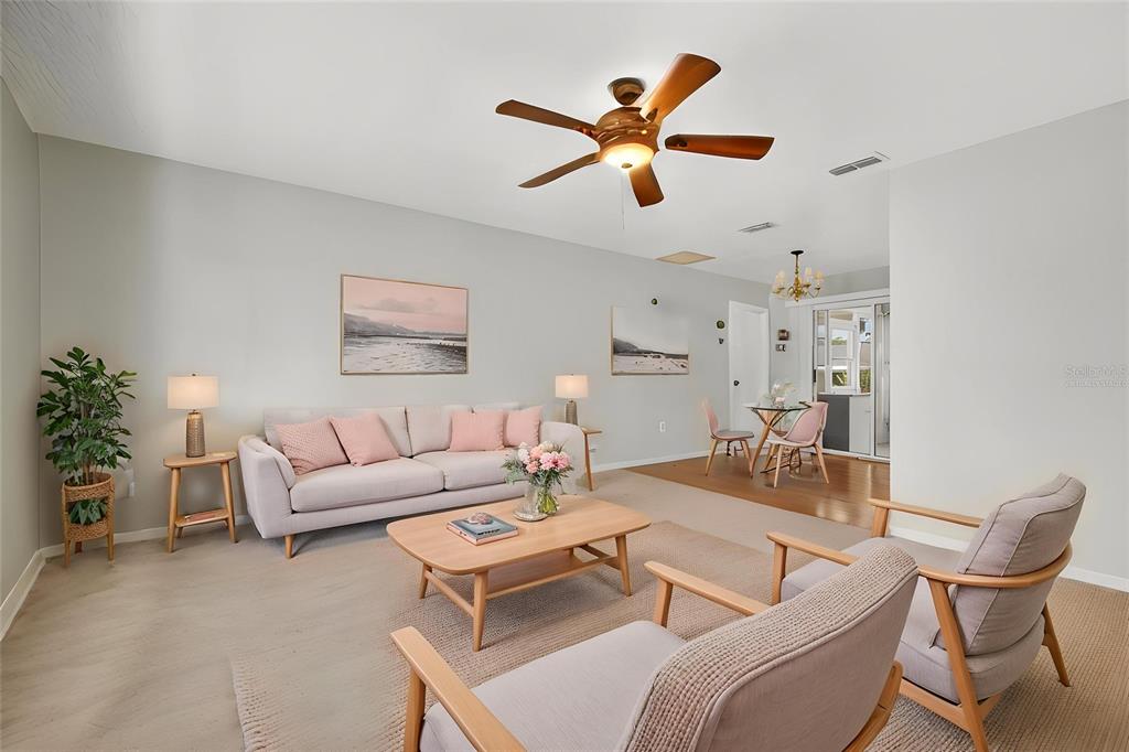 A living room features a light-colored sofa, two armchairs, a coffee table, and dining area — 8720 SW 108TH LANE, OCALA, FL