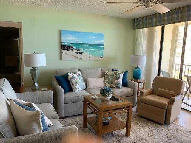 A living room features a light green wall, a beige sofa, and a tan armchair — 300 Ocean Trail Way # 602, Jupiter FL 33477, JUPITER, FL