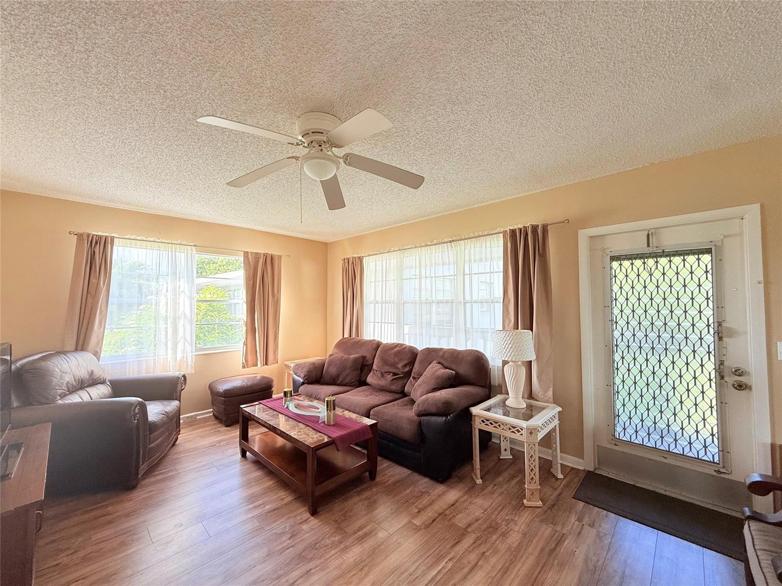 A living room features a brown sofa, leather armchair, coffee table, and a ceiling fan — 204 Oakridge M # 204, Deerfield Beach FL 33442, DEERFIELD BEACH, FL