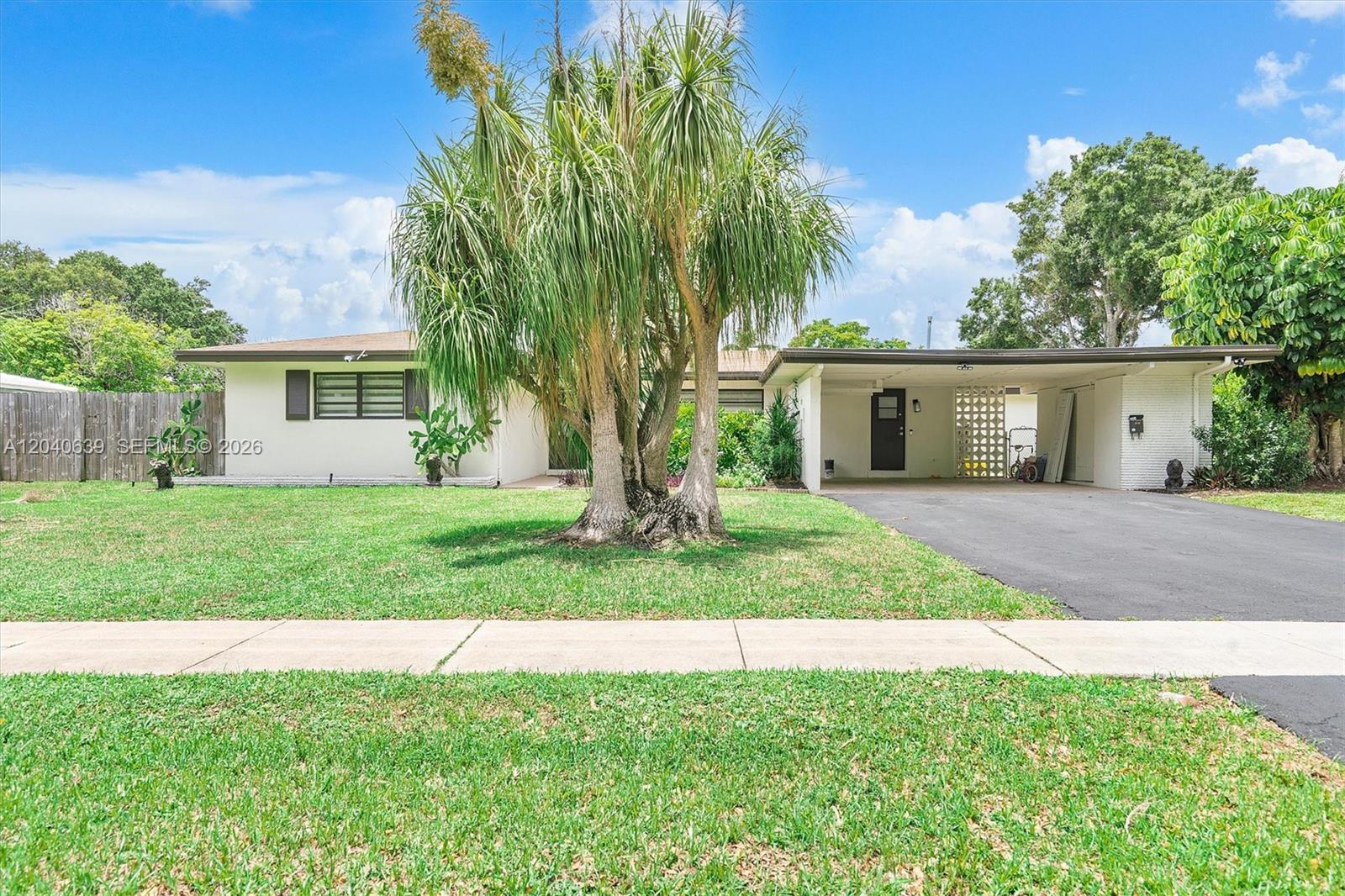 A single-story house with a carport, a large palm tree, and a grassy front yard — 885 Azalea Ct, Plantation FL 33317, PLANTATION, FL