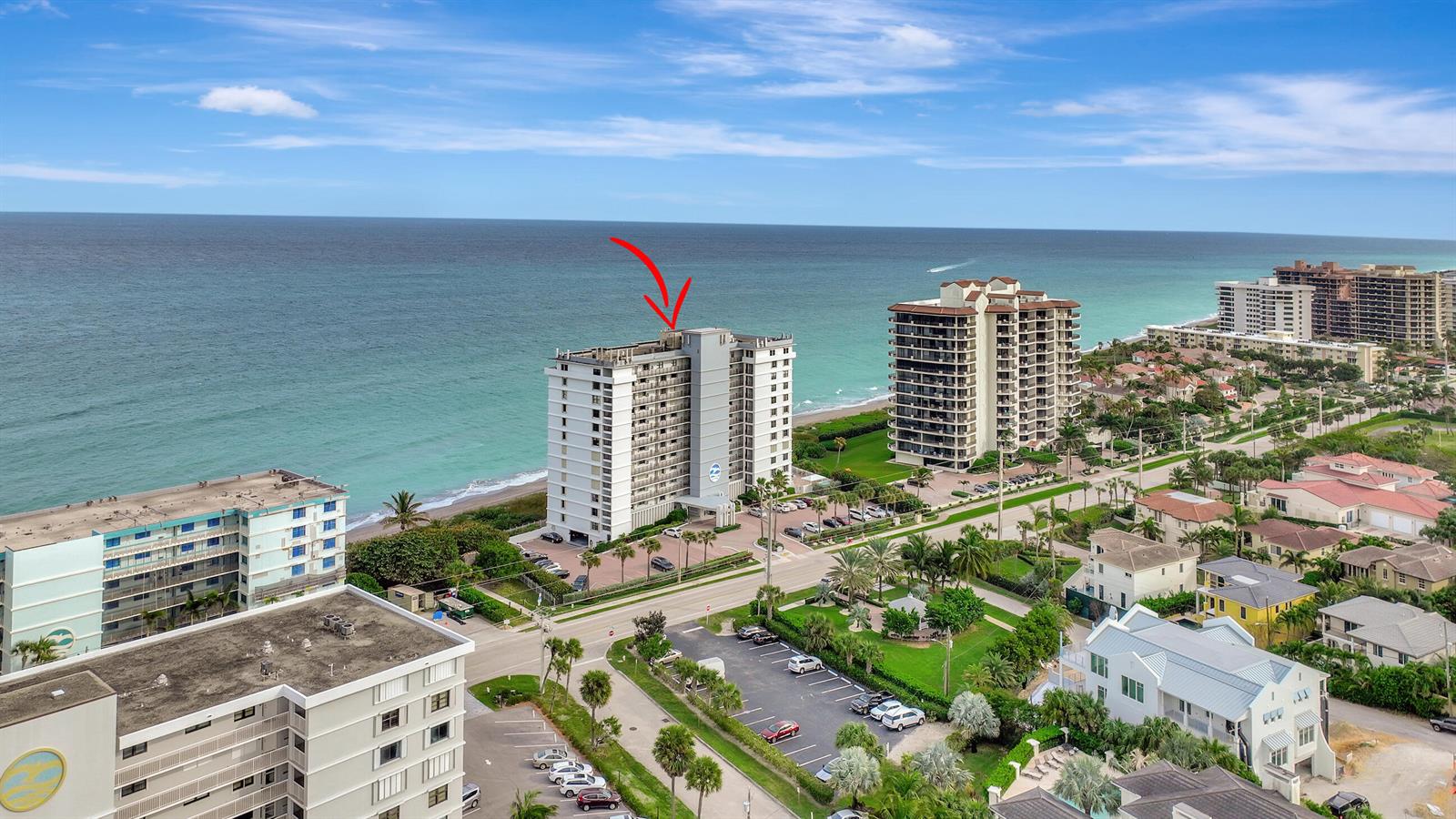 An aerial view shows a tall beachfront condominium building with a red arrow pointing toward it — 840 Ocean Drive # 806, Juno Beach FL 33408, JUNO BEACH, FL