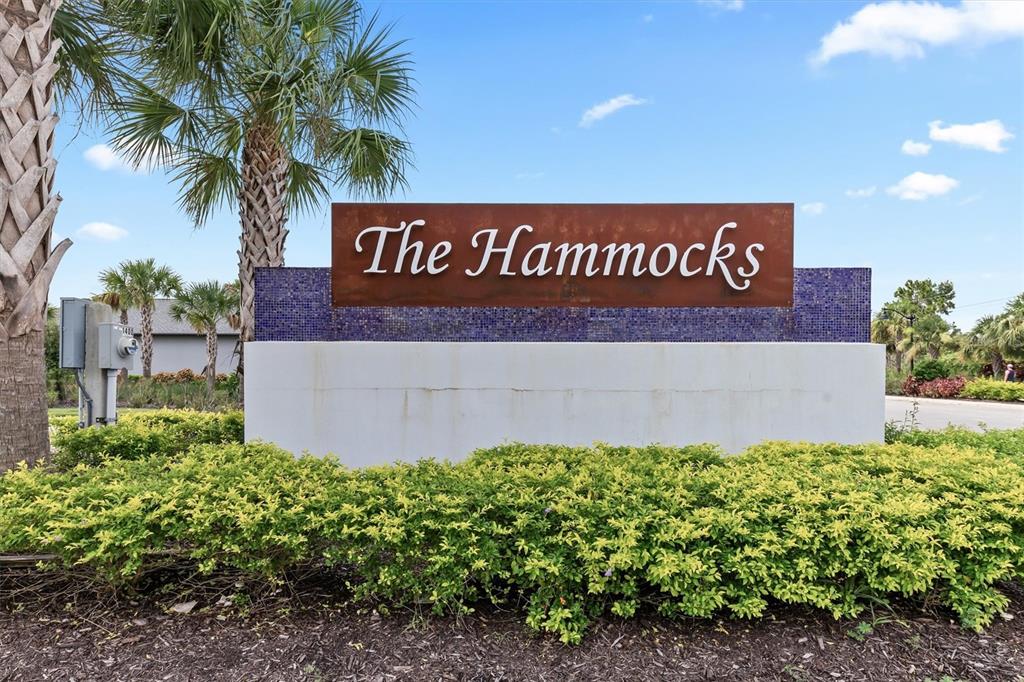 A sign reading The Hammocks stands in front of a hedge and palm trees — 1736 SUNSET PRESERVE WAY, PORT CHARLOTTE, FL
