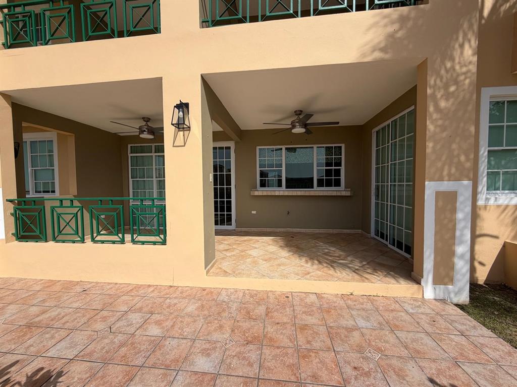 An empty room features diagonal tile flooring, a ceiling fan, and glass doors leading outside — 968 COSTA DORADA UNIT A-102, RIO GRANDE, PR