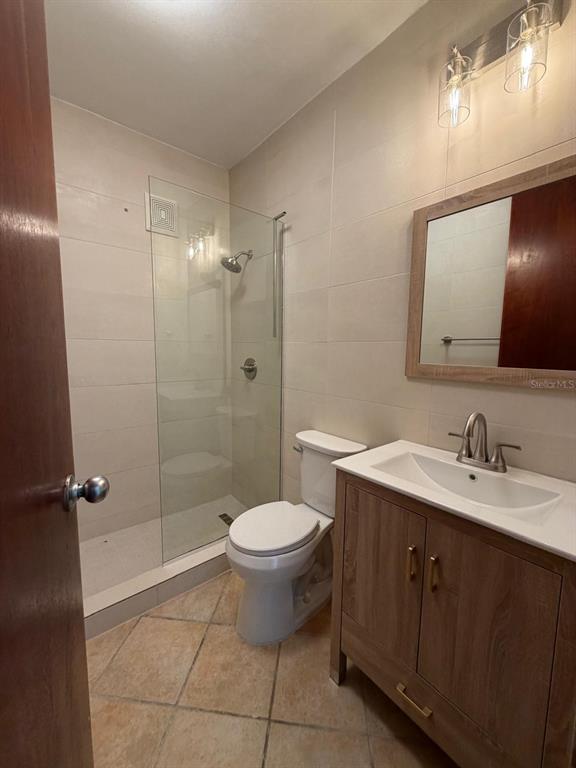 A kitchen features wood cabinets, stainless steel appliances, tile flooring, and a ceiling fan — 968 COSTA DORADA UNIT A-102, RIO GRANDE, PR