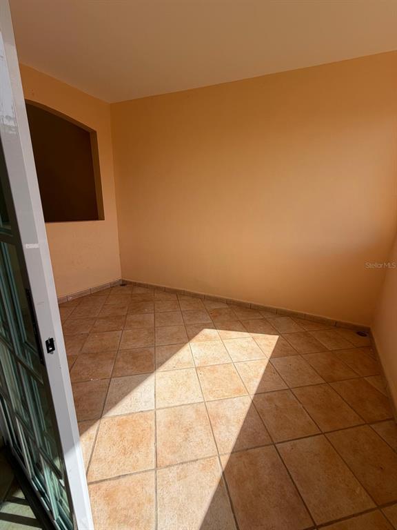 A bathroom features tiled walls, a toilet, a vanity with a sink, and sailboat artwork — 968 COSTA DORADA UNIT A-102, RIO GRANDE, PR