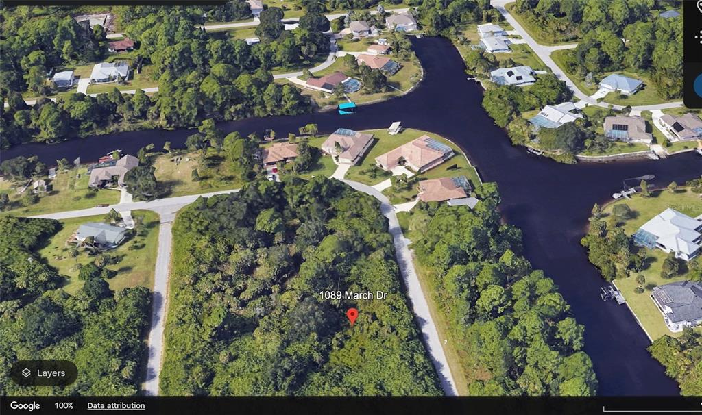 This is an aerial map view of a wooded residential lot near a canal — 1089 MARCH DRIVE, PORT CHARLOTTE, FL