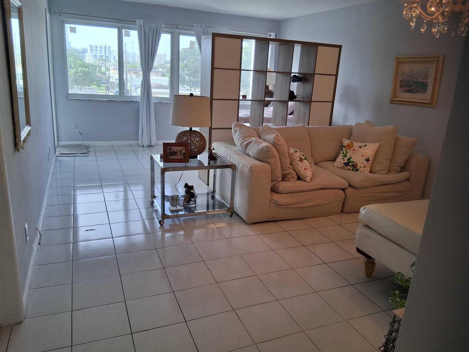 A living room features white tile floors, a beige sectional sofa, and a room divider — 329 SE 3rd Street # 302s, Hallandale Beach FL 33009, HALLANDALE BEACH, FL