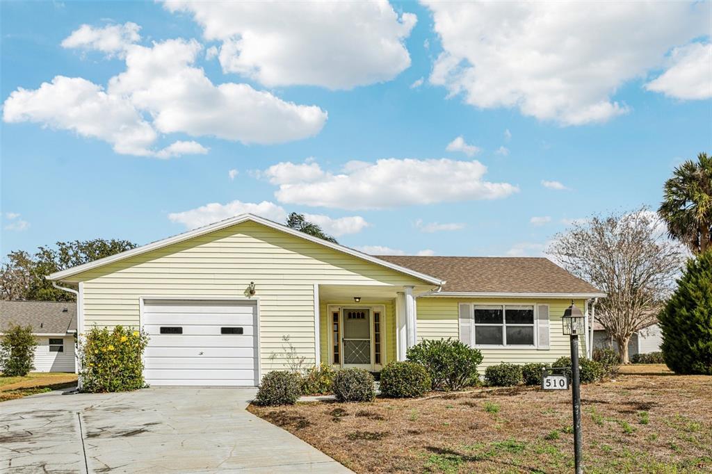 A single-story yellow house with a one-car garage and a front yard — 510 GALLOWAY COURT, LEESBURG, FL