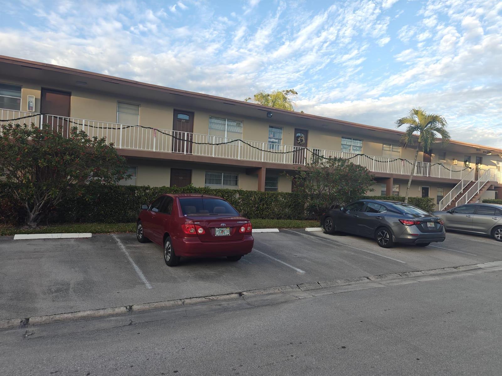 An exterior view of a two-story apartment building with a parking lot in front — 7505 NW 5th Place # 106, Margate FL 33063, MARGATE, FL