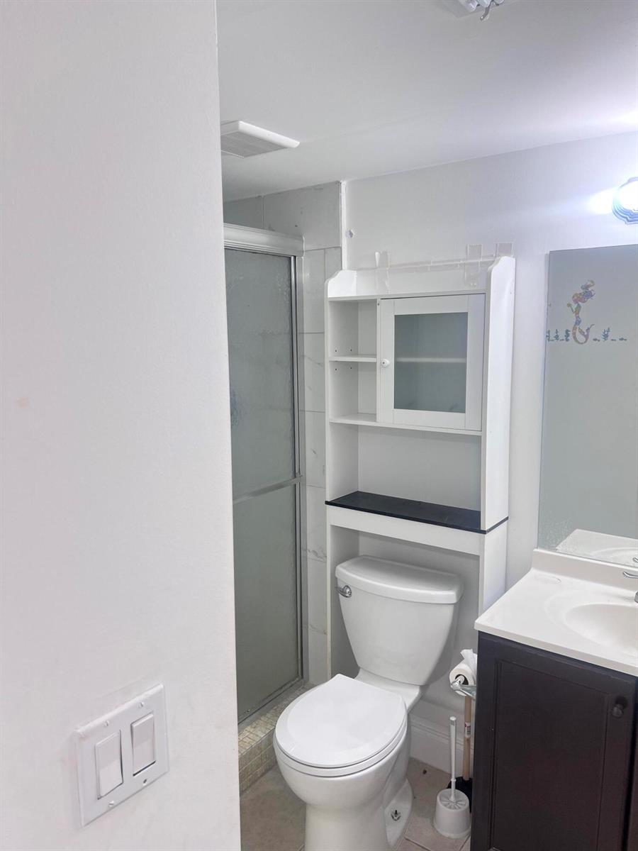 A bathroom features a toilet with an over-the-toilet storage unit, a vanity, and a shower — 7505 NW 5th Place # 106, Margate FL 33063, MARGATE, FL