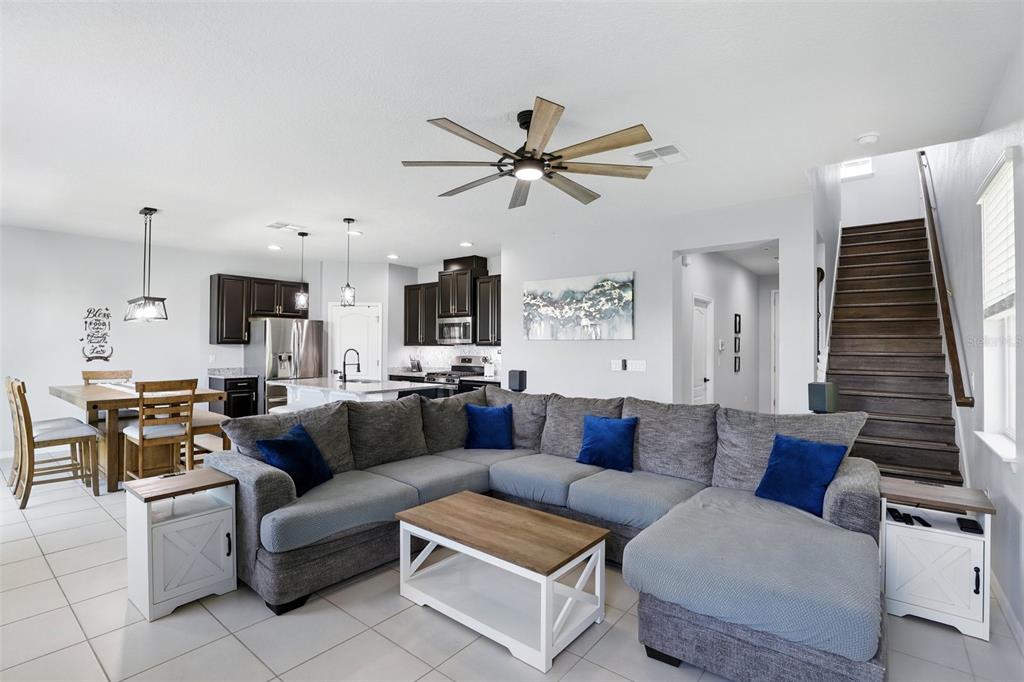 A living room with a gray sectional sofa, wooden coffee table, and open-concept kitchen — 1338 RILEY CIRCLE, DELAND, FL