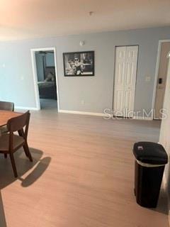 A dining area with light wood flooring, a framed wall picture, and a closed closet — 11313 SW 95TH CIRCLE, OCALA, FL