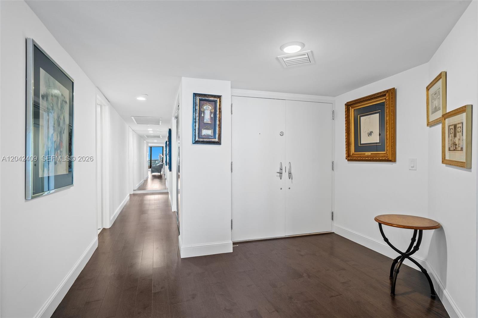 A white-walled entryway features dark wood flooring, double doors, and several framed wall art pieces — 1500 S Ocean Blvd # 804, Boca Raton FL 33432, BOCA RATON, FL