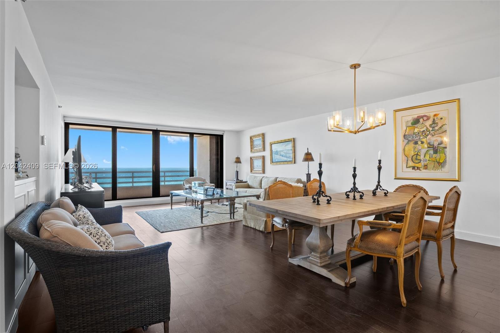 A living and dining room with dark wood floors, ocean views, and a chandelier — 1500 S Ocean Blvd # 804, Boca Raton FL 33432, BOCA RATON, FL