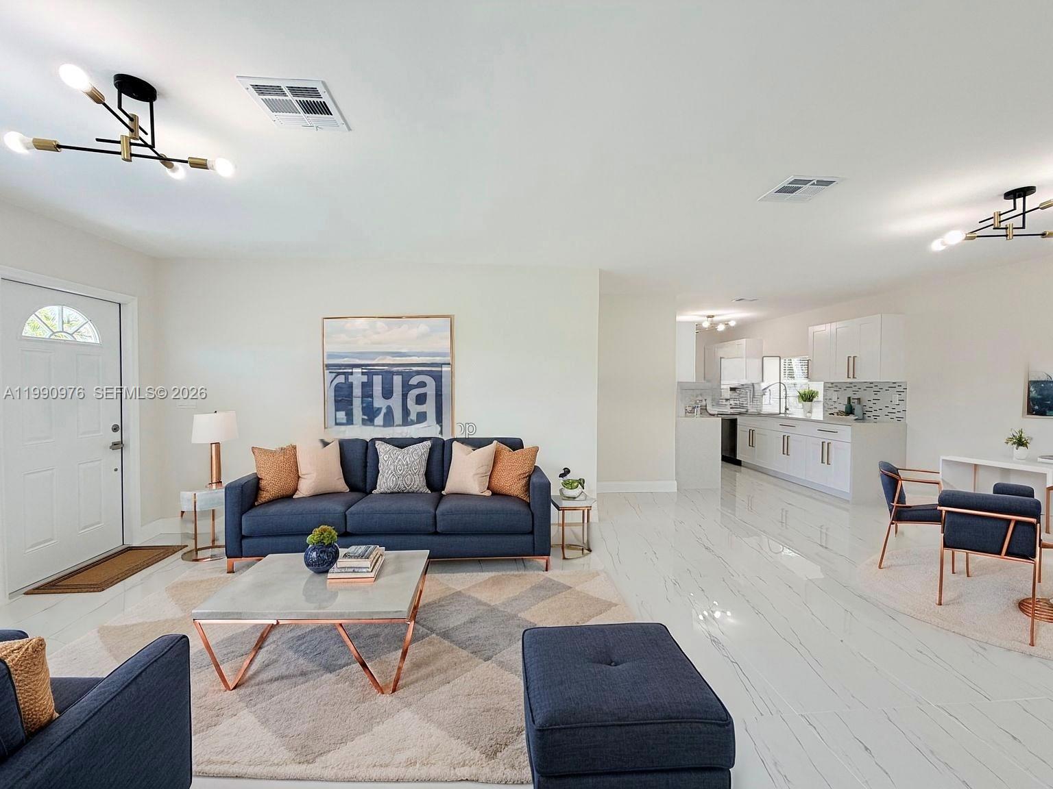 An open-concept living room and kitchen feature white marble-look tile floors and navy furniture — 4731 NW 11th St, Lauderhill FL 33313, LAUDERHILL, FL
